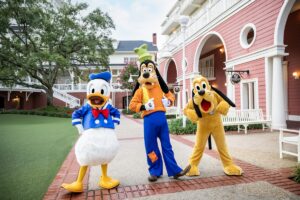 donald duck, goofy, and pluto walking around a resort at walt disney world