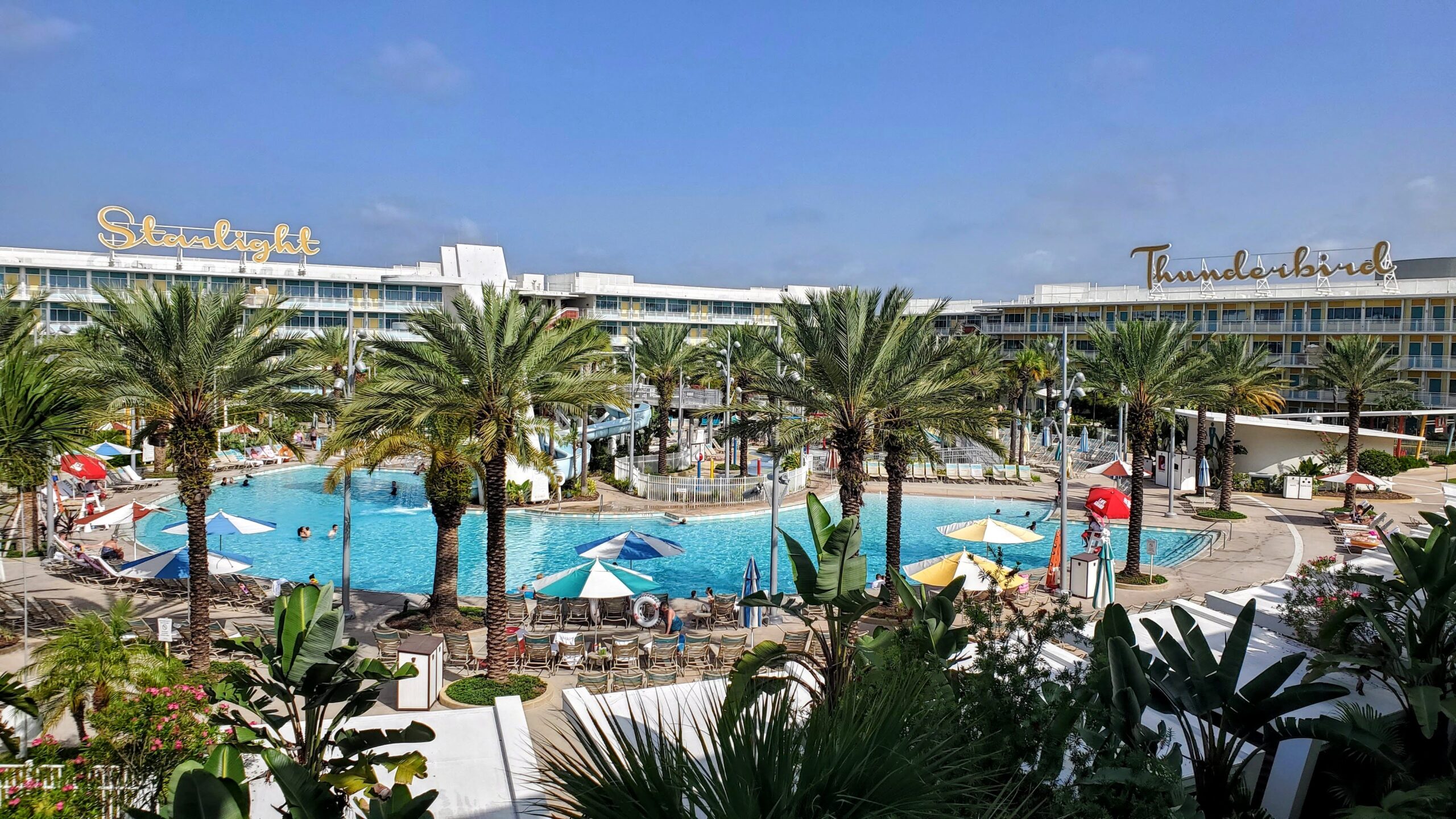 the pool at cabana bay beach resort along with the hotel buildings and palm trees