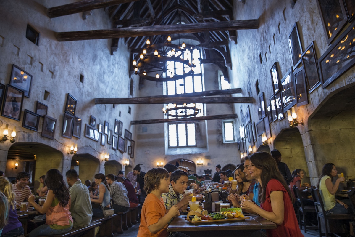 people eating a meal at the leaky cauldron, an indoor restaurant at the wizarding world of harry potter