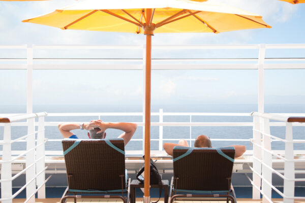 people relaxing on the deck of a carnival cruise line ship