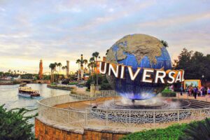 universal studios globe icon in the foreground with the lagoon behind it at universal orlando resort