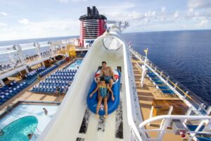 two people on a water slide that is on the top deck of a cruise ship