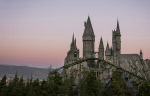 a wide shot of flight of the hippogriff roller coaster and hogwarts castle at the wizarding world of harrry potter in universal studios hollywood