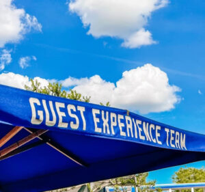 guest experience team umbrella with sky in the background
