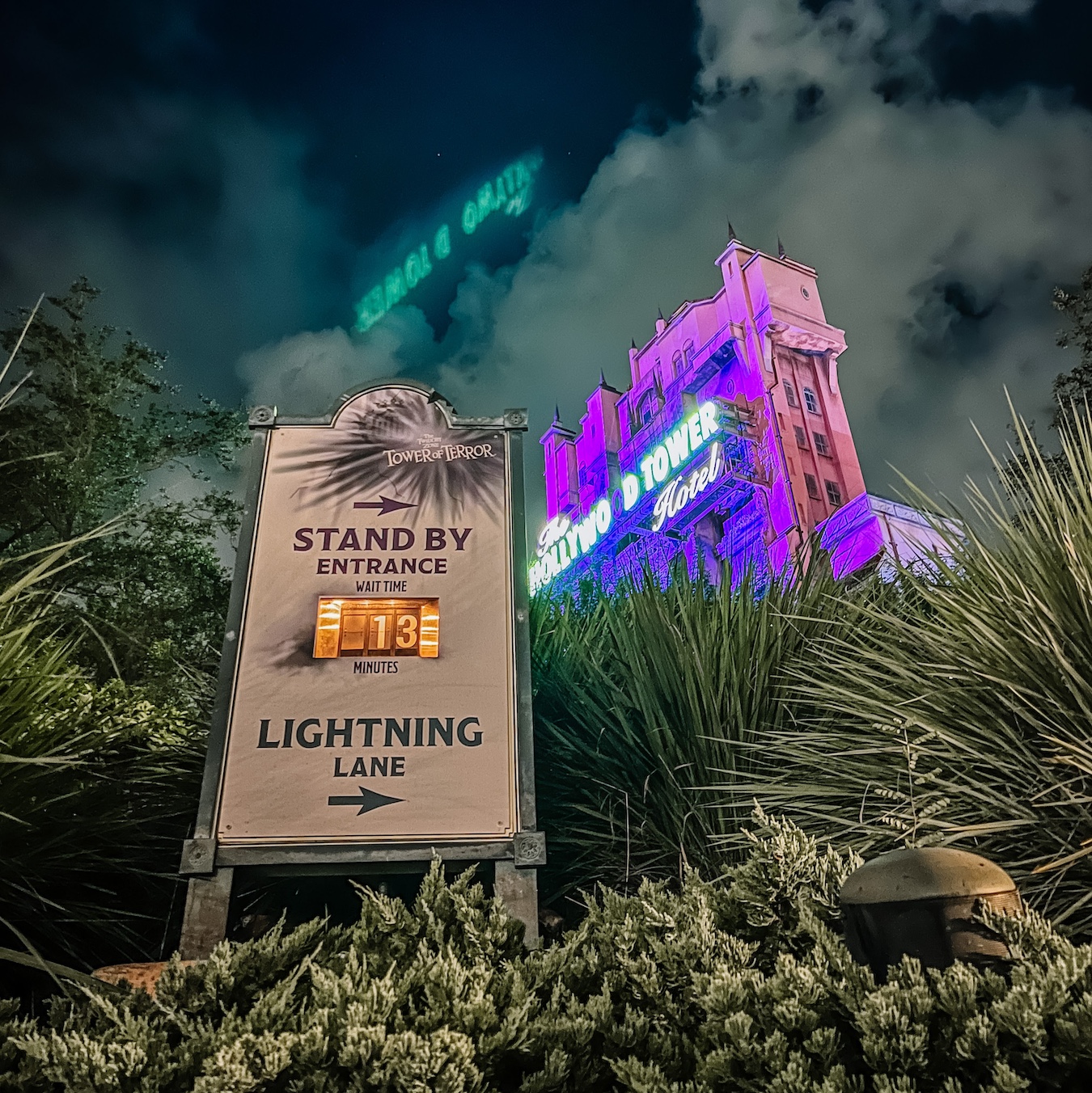 the queue sign for tower of terror with the hollywood hotel show building in the background