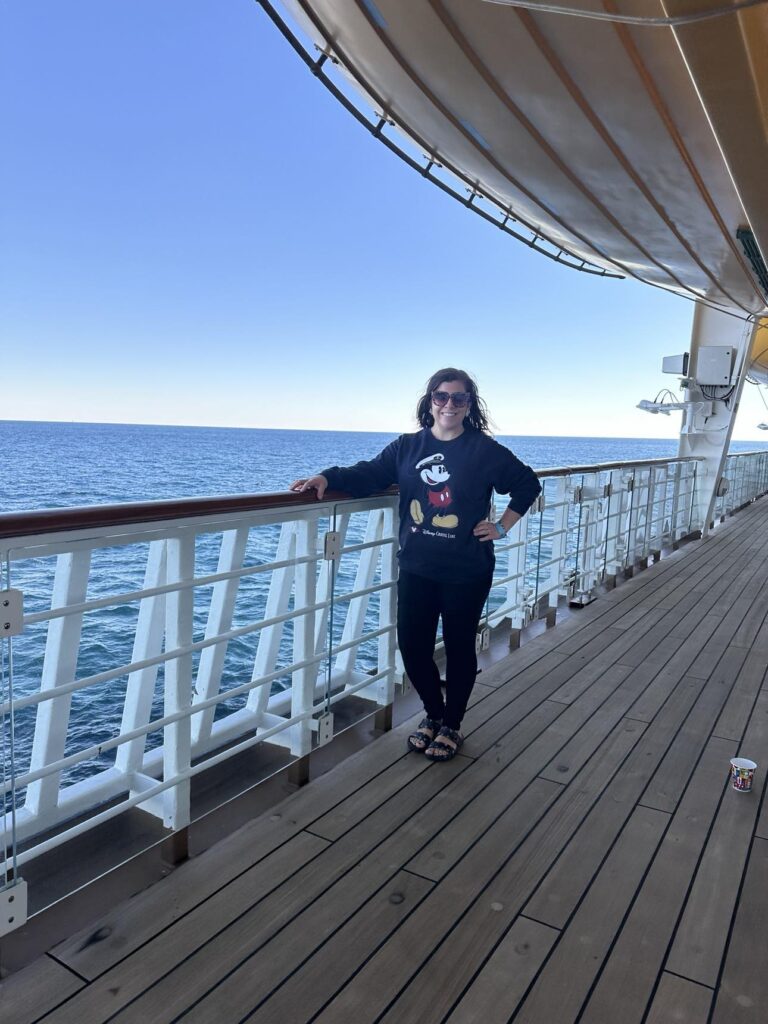 Autumn Orosz standing on the balcony of a disney cruise line ship