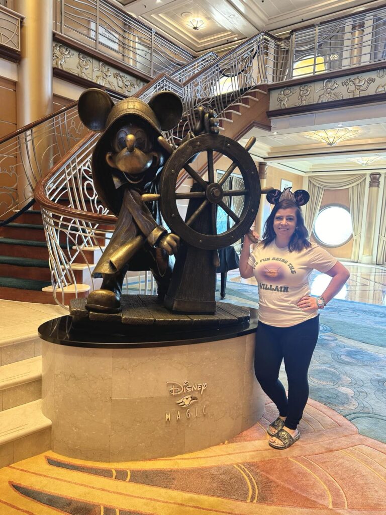 autumn standing next to a statue on a disney cruise line ship